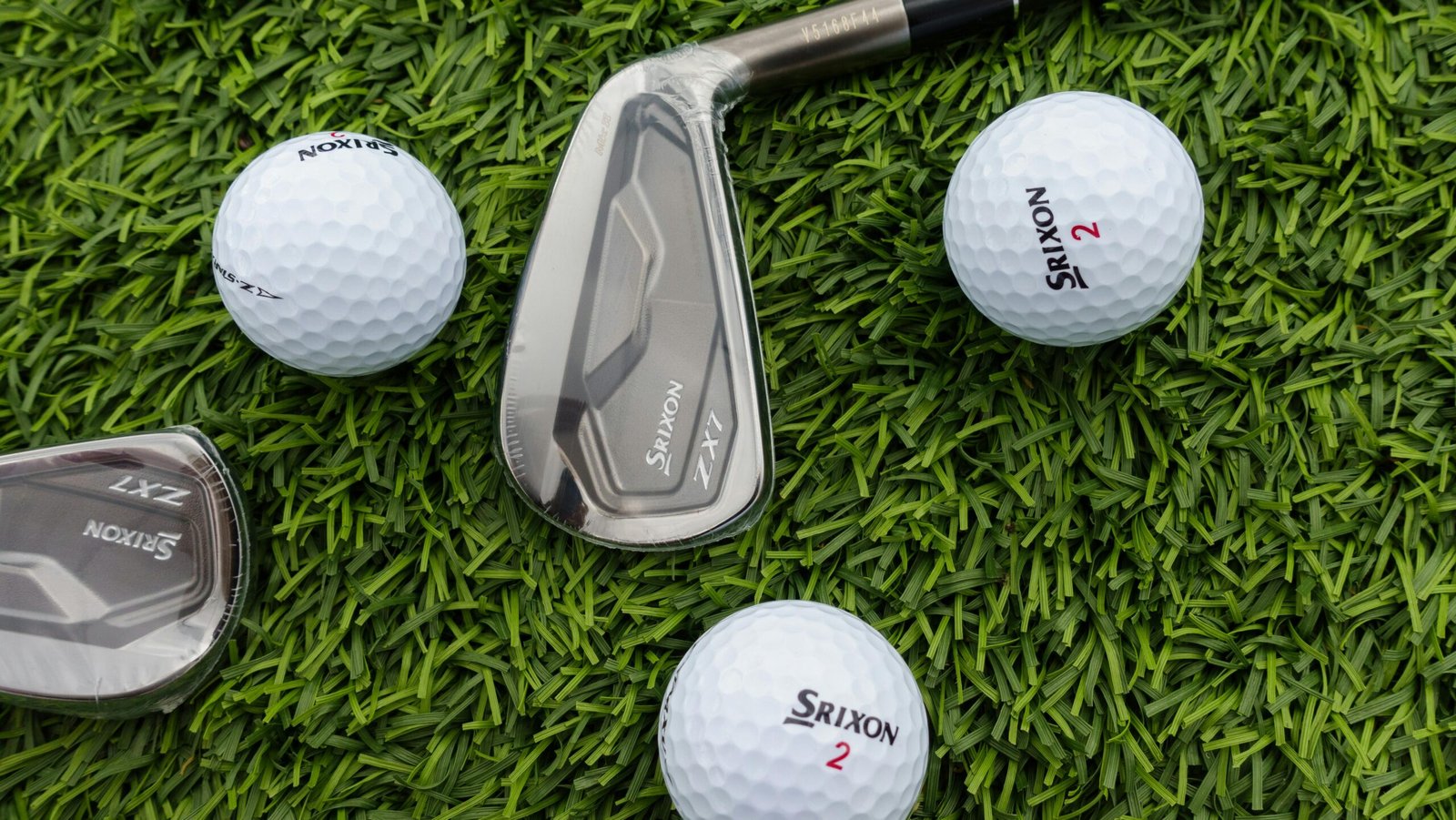 Services Golf clubs and balls arranged on vibrant green grass, perfect for sports enthusiasts.